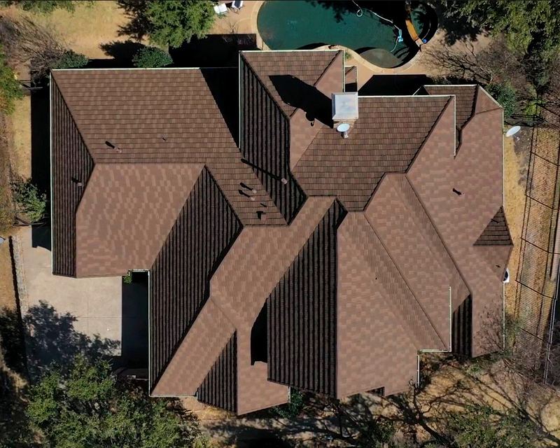 Top-down aerial of a home with a new brown architectural shingle roof by Benchmark Roofing and Construction