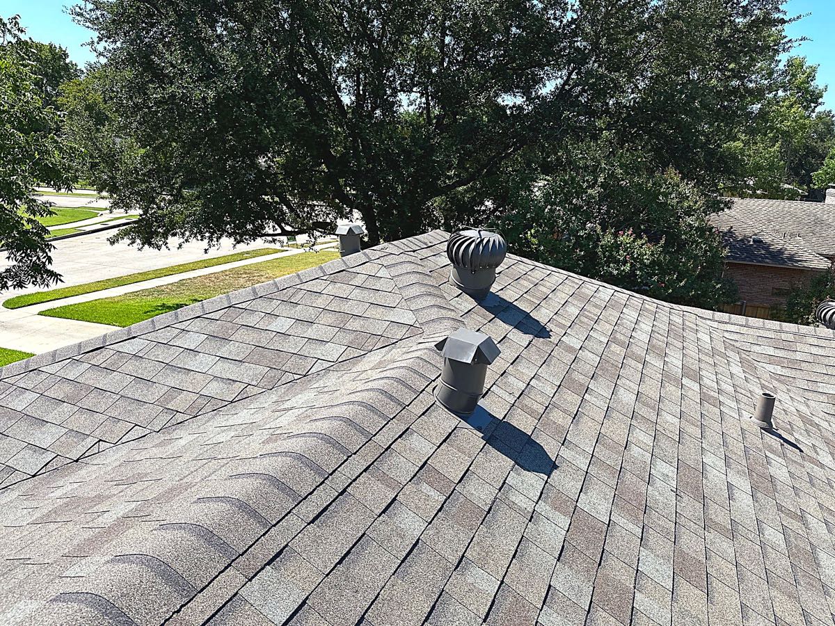 Turbine vents exhausting attic heat on an asphalt shingle roof in Garland, TX