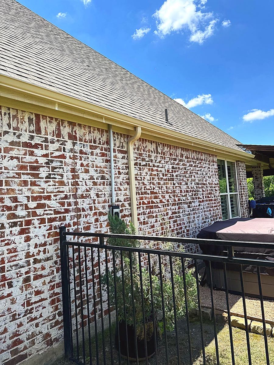 Shingle roof edge and gutter on a whitewashed brick ranch home typical of Lake Highlands and Northeast Dallas
