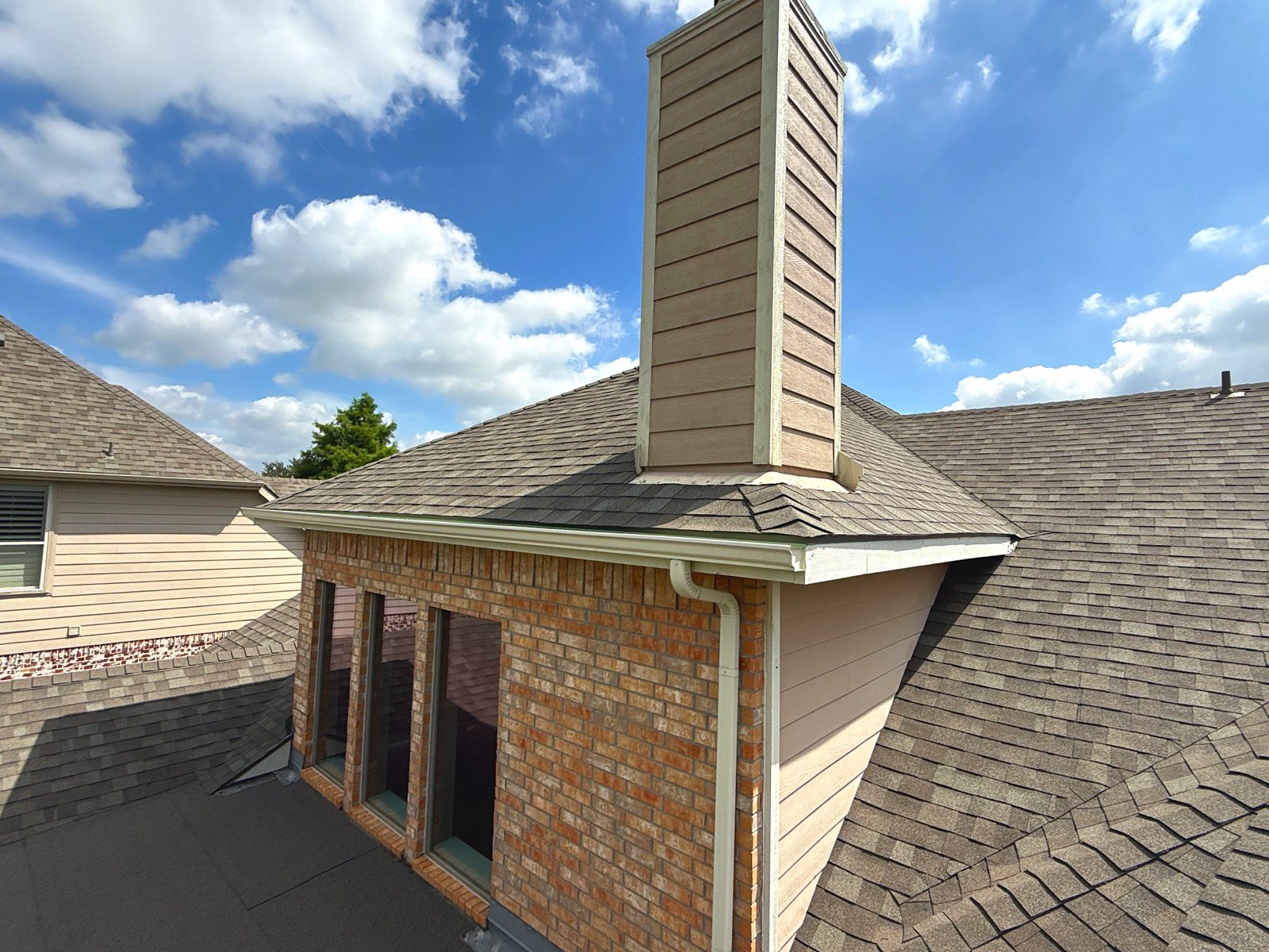 Roof repair with new chimney flashing by Benchmark Roofing and Construction