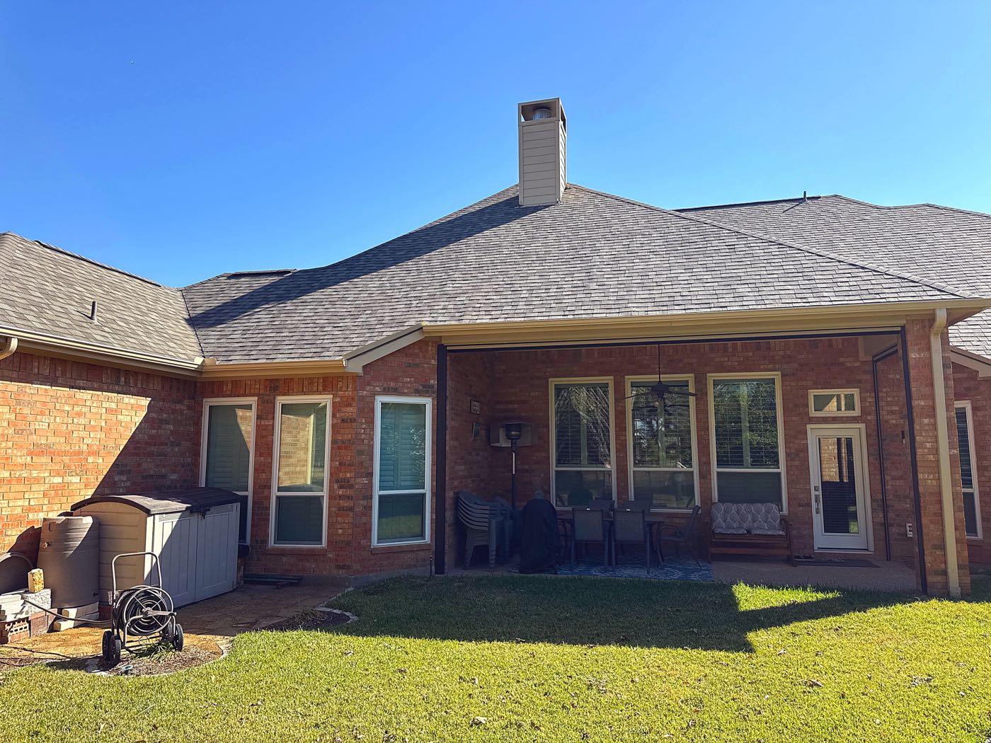 Completed architectural shingle roof replacement on a single-story brick home in the Dallas area by Benchmark Roofing and Construction