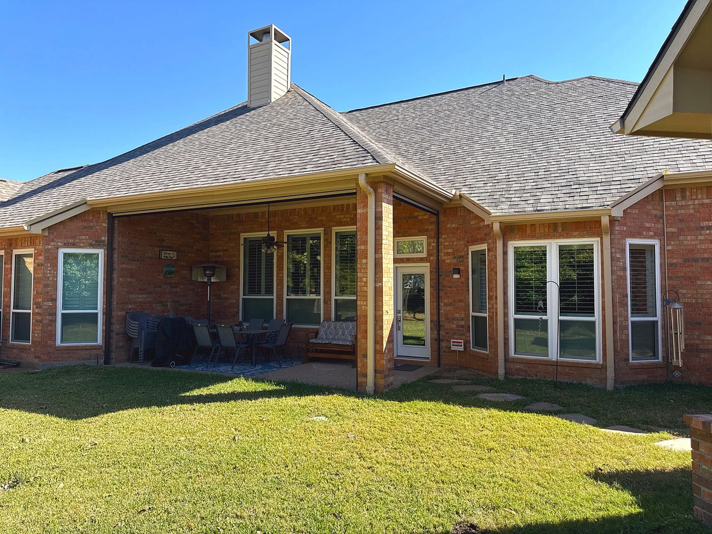 Completed shingle roof replacement over a covered patio, the kind of wind-exposed roofline common on homes near Lake Ray Hubbard in Rowlett