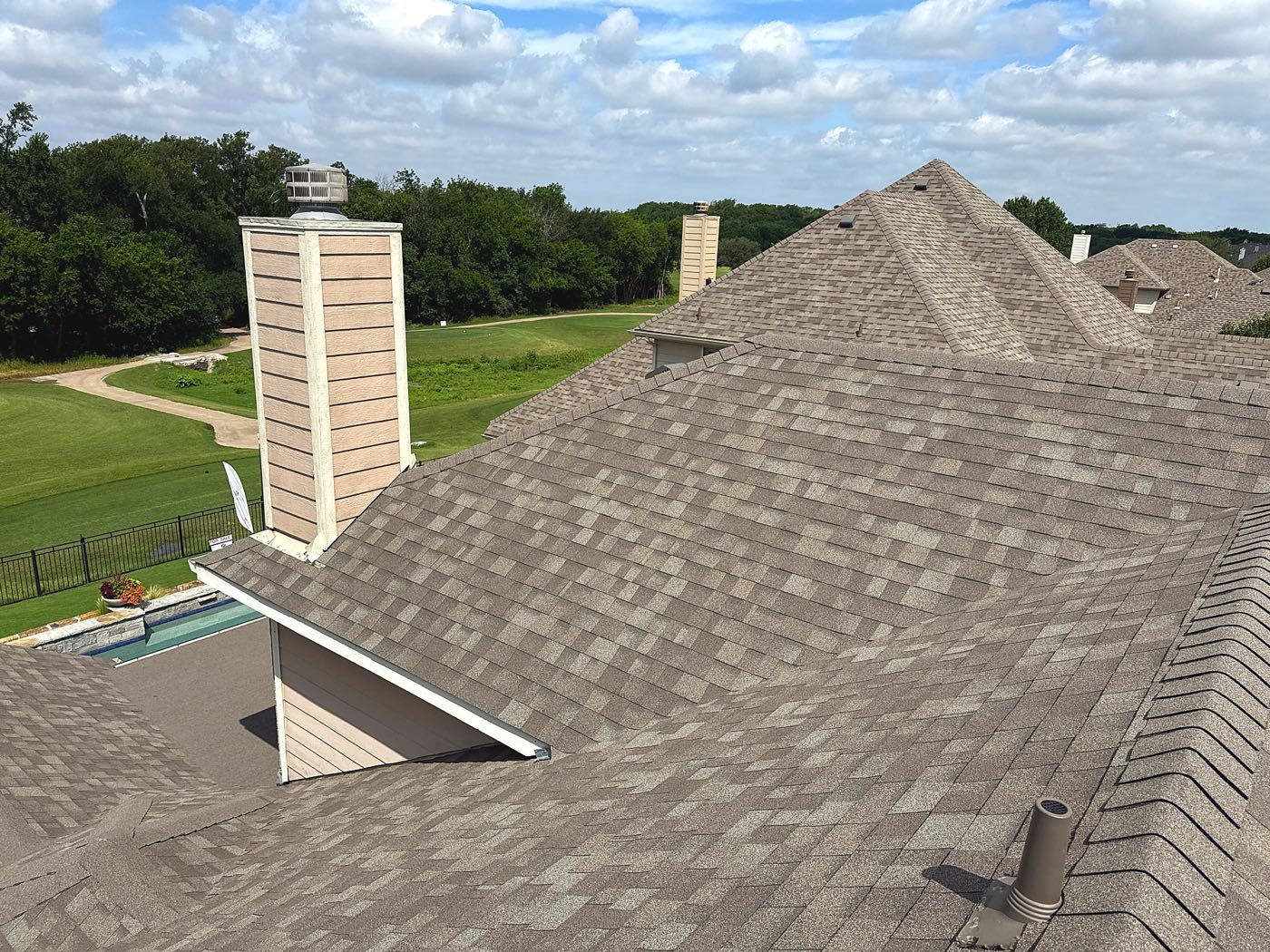 Shingle roof replacement on a golf-course home in the Sachse, TX area by Benchmark Roofing and Construction
