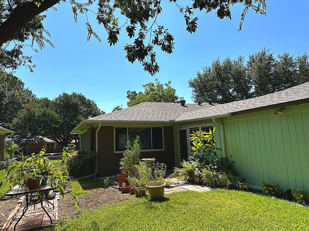 Completed asphalt shingle roof replacement on a ranch-style brick home in Garland, TX by Benchmark Roofing and Construction