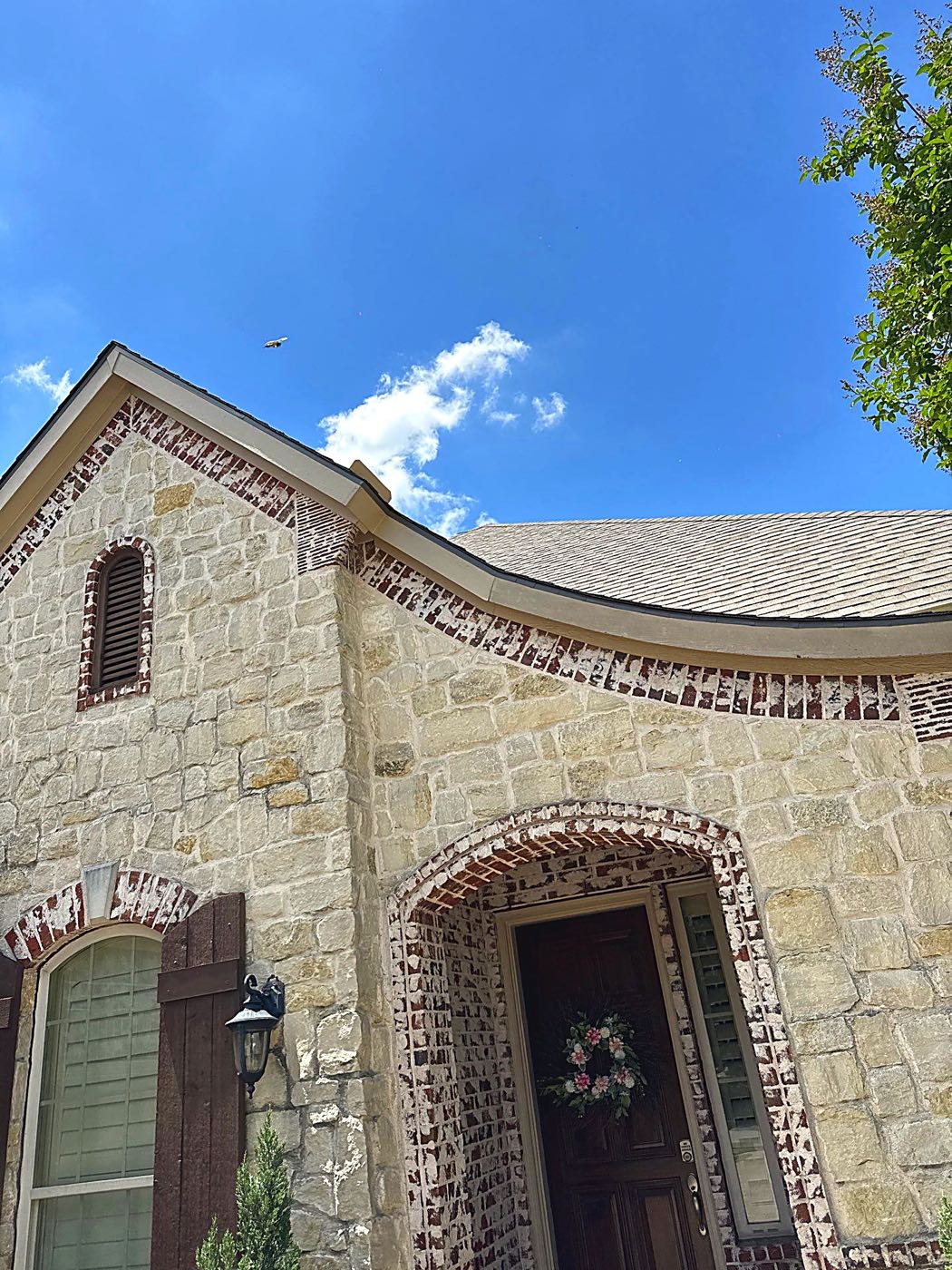 Class 4 impact-resistant shingle roof installed on a stone-front home in Garland, TX by Benchmark Roofing